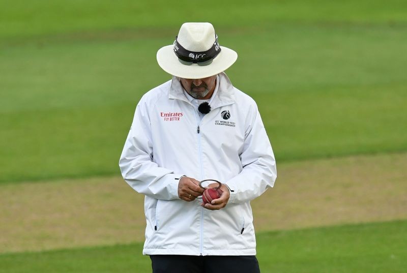 An umpire checks the shape of the ball, as play resumes behind closed doors following the outbreak of the coronavirus disease (COVID-19) Dan Mullan/Pool via REUTERS/Files