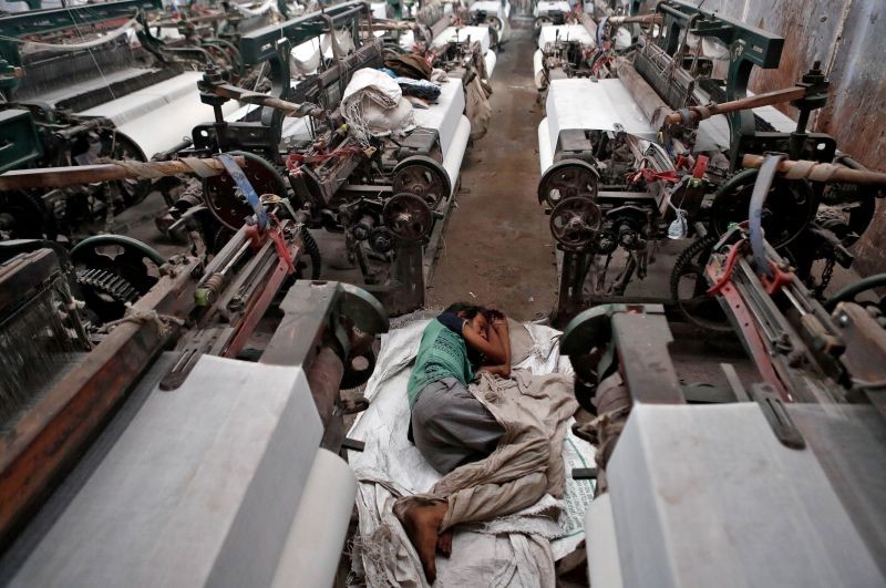 A migrant worker, who works in a textile loom, rests inside a loom after it was shut due to the 21-day nationwide lockdown to slow the spread of the coronavirus disease, in Bhiwandi on the outskirts of Mumbai, India, April 1, 2020. (REUTERS File Photo)