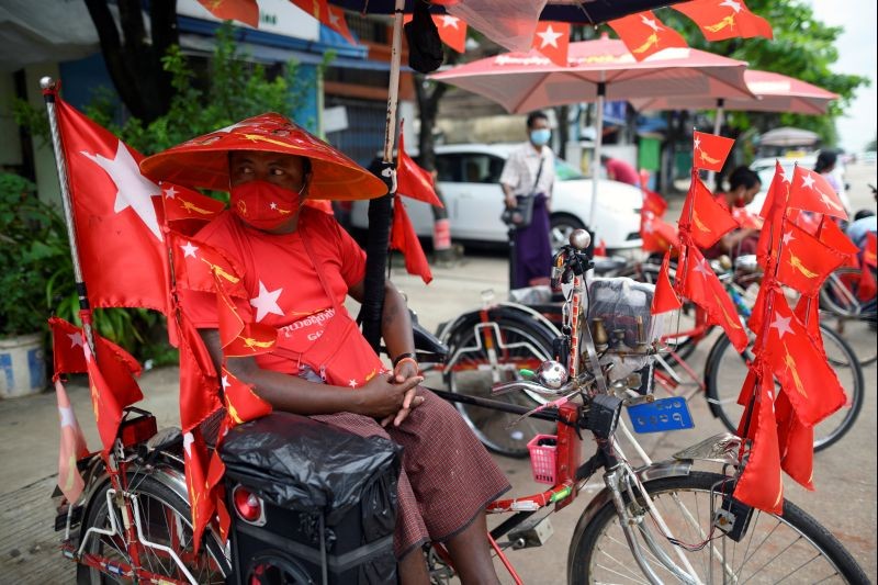 A trishaw driver wearing a face mask and a hat with pictures of country's leader Aung San Suu Kyi waits for his customer amid the coronavirus disease (COVID-19) spread, in Yangon, Myanmar on October 2, 2020. (REUTERS Photo)