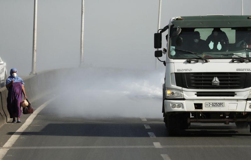 A woman wearing a face mask walks next to a truck spraying disinfectant on the street as part of measures to prevent the potential spread of coronavirus (COVID-19), in Addis Ababa, Ethiopia March 29, 2020. (REUTERS File Photo)