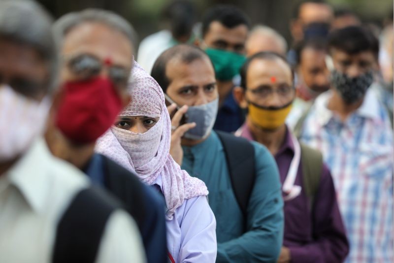 People wearing protective masks wait in line to board a bus amidst the spread of the coronavirus disease (COVID-19) in Mumbai on October, 6, 2020. (REUTERS Photo)