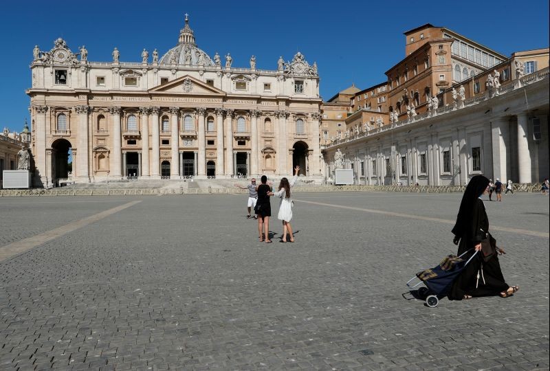 A nun passes by tourists taking pictures on St. Peter's Square as Pope Francis gives his weekly general audience virtually from a library inside the Vatican due to measures to contain the coronavirus disease (COVID-19), at the Vatican August 5, 2020. (REUTERS File Photo)