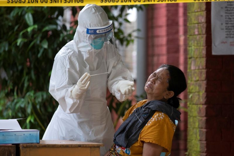 A woman reacts while getting a coronavirus swab test by medical staff at a quarantine centre amid the COVID-19 outbreak in Yangon, Myanmar, October 7, 2020. (REUTERS Photo)