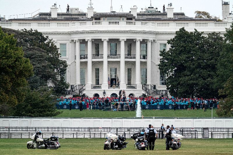 U.S. President Donald Trump stands on a White House balcony speaking to supporters gathered on the South Lawn for a campaign rally that the White House is calling a "peaceful protest" in Washington, U.S., October 10, 2020. REUTERS/Ken Cedeno