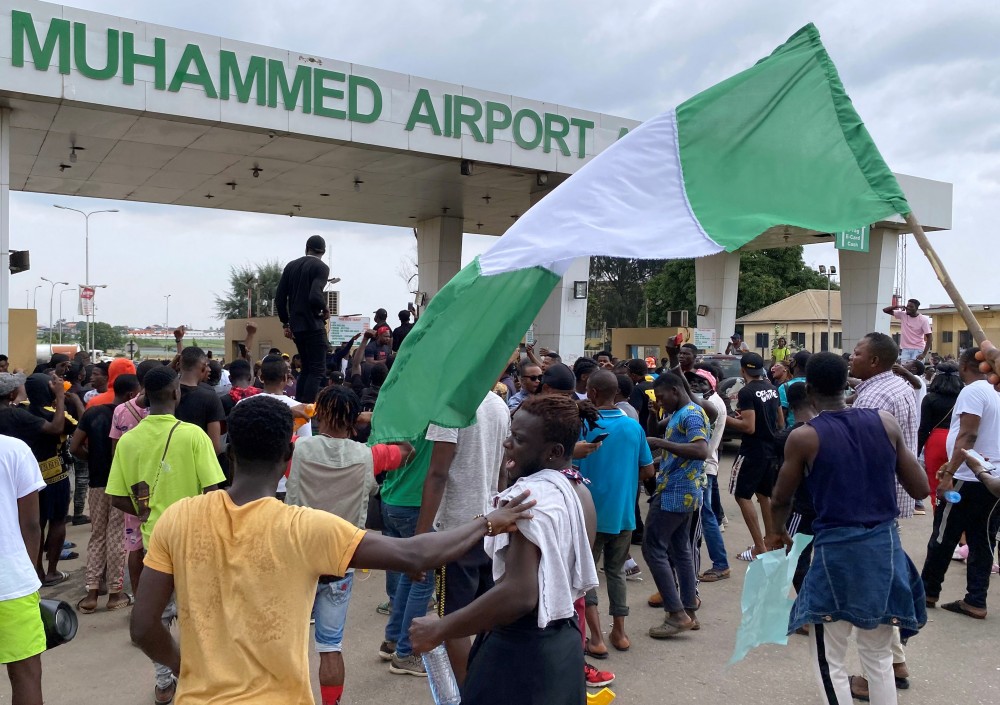 Demonstrators carry flags and banners as they block a road leading to the airport during a protest over alleged police brutality in Lagos, Nigeria October 15, 2020. REUTERS/Seun Sanni