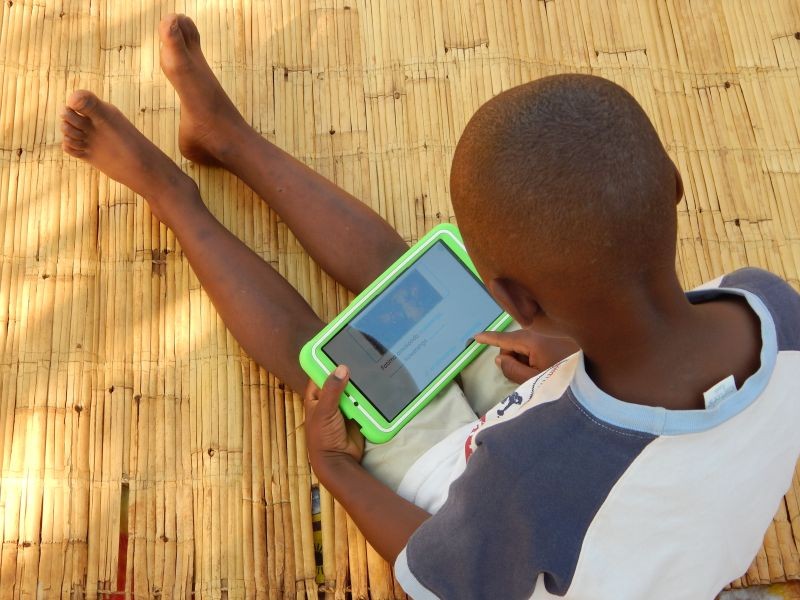 Eight-year-old Elijah Chiseka uses a learning tablet provided by the charity Voluntary Service Overseas in Gumulira village in western Malawi, September 23, 2020. (REUTERS File Photo)