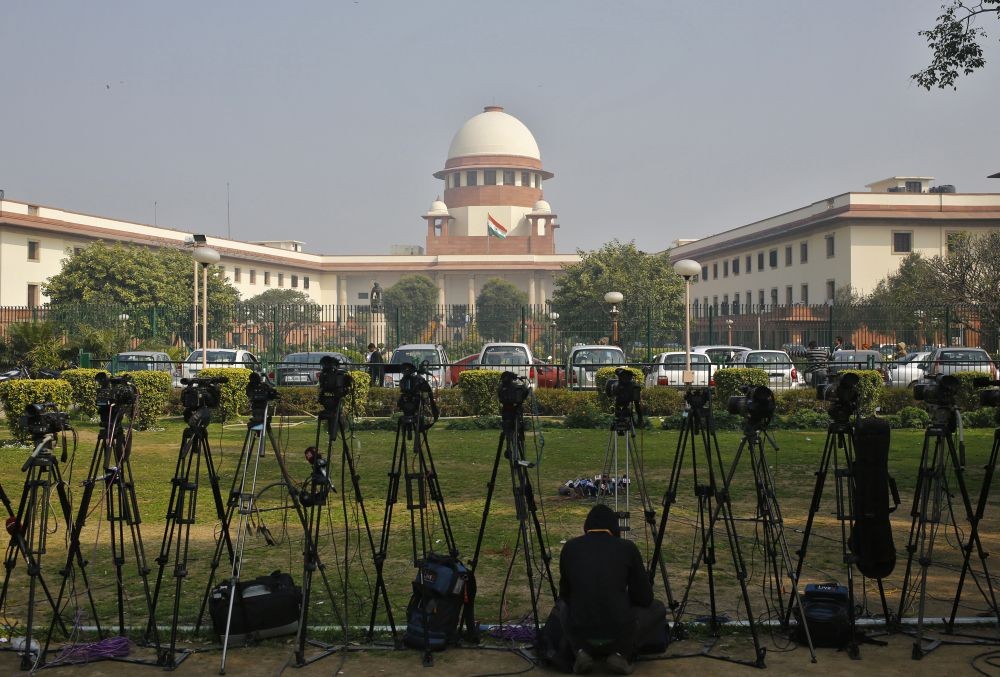 File Photo: A television journalist sets his camera inside the premises of the Supreme Court in New Delhi February 18, 2014. REUTERS/Anindito Mukherjee/FILE PHOTO