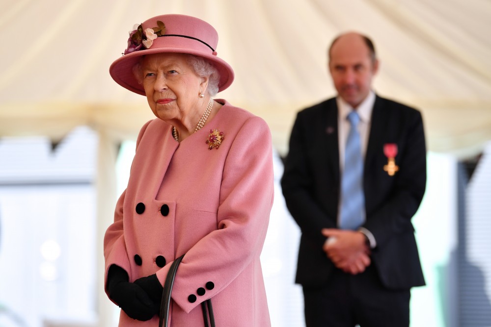 Britain's Queen Elizabeth speaks with staff including Professor Tim Atkins (R), who was honoured for his work on the 2018 Novichok incident and has been involved in the fight against COVID-19, during a visit to Dstl at Porton Science Park near Salisbury, Britain October 15, 2020. Ben Stansall/Pool via REUTERS