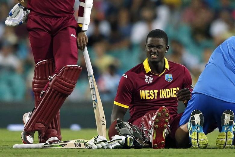 West Indies captain Jason Holder reacts after receiving treatment for cramps, as his teammate Denesh Ramdin (L) stands next to him, during their Cricket World Cup match against South Africa at the Sydney Cricket Ground (SCG) February 27, 2015. REUTERS/Jason Reed
