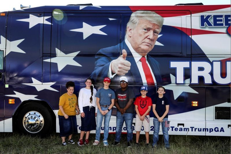 Supporters of U.S. President Donald Trump pose for photos in front of a bus with his image on it as they gather outside his campaign event in Macon, Georgia, U.S., October 16, 2020. (REUTERS Photo)