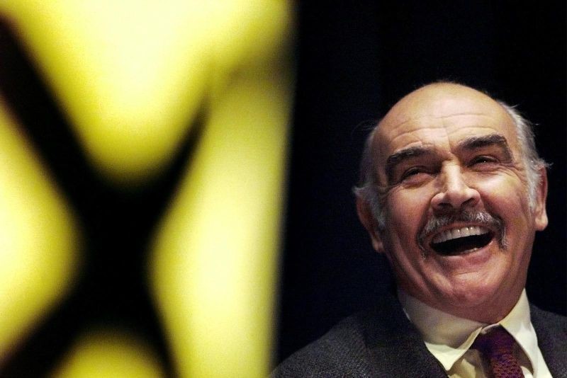 FILE PHOTO: Actor Sean Connery laughs as he listens to a speech by Alex Salmond at a Scottish National Party rally at the Edinburgh International conference centre April 26. REUTERS/Jeff J Mitchell