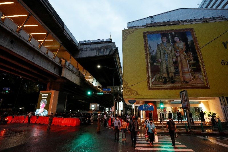 People cross the street as police close a road nearby, in Bangkok, Thailand October 16, 2020. REUTERS/Jorge Silva