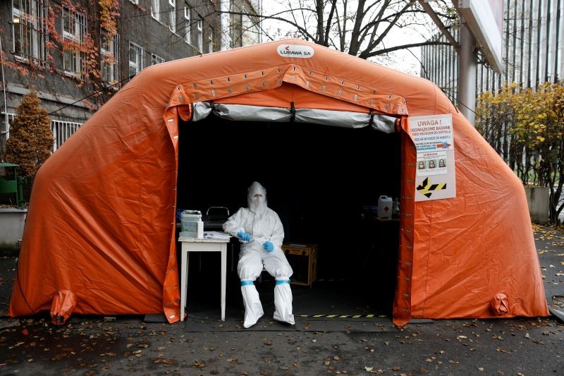 FILE PHOTO: A health worker in protective suit waits for people at a test center in front of a hospital, amid the coronavirus disease (COVID-19) outbreak, in Warsaw, Poland October 27, 2020. REUTERS/Kacper Pempel/File Photo