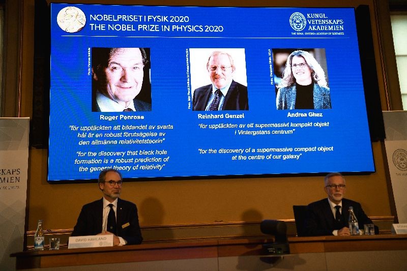 David Haviland, member of the Nobel Committee for Physics and Secretary General of the Royal Swedish Academy of Sciences Goran K. Hansson announce the winners of the 2020 Nobel Prize in Physics presented on the screen: Roger Penrose, Reinhard Genzel and Andrea Ghez during a news conference at the Royal Swedish Academy of Sciences, in Stockholm, Sweden October 6, 2020.  TT News Agency/Fredrik Sandberg via REUTERS
