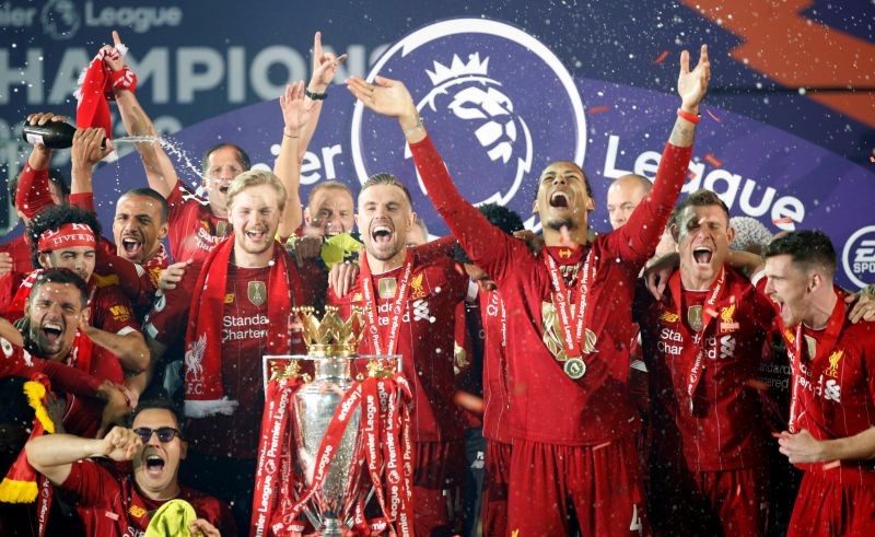 Liverpool's Jordan Henderson with teammates celebrates with the trophy after winning the Premier League Pool via REUTERS/Phil Noble