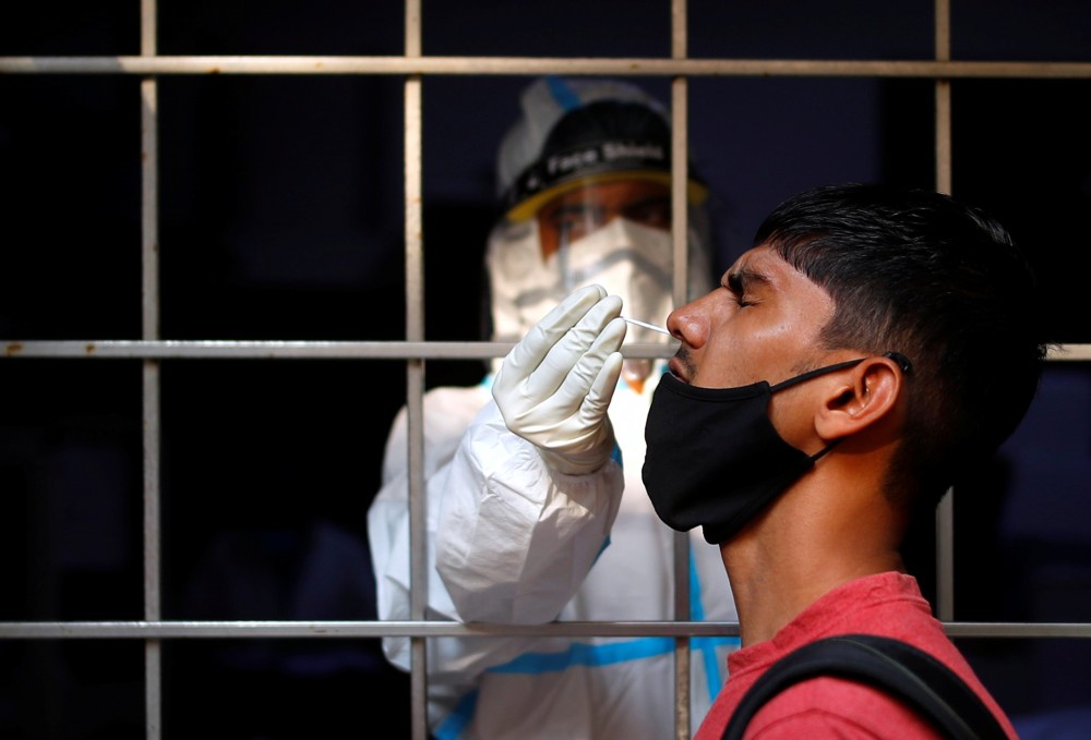 A man reacts as a healthcare worker collects a swab sample amidst the spread of the coronavirus disease (COVID-19), at a testing centre, in New Delhi, India October 17, 2020. REUTERS/Adnan Abidi