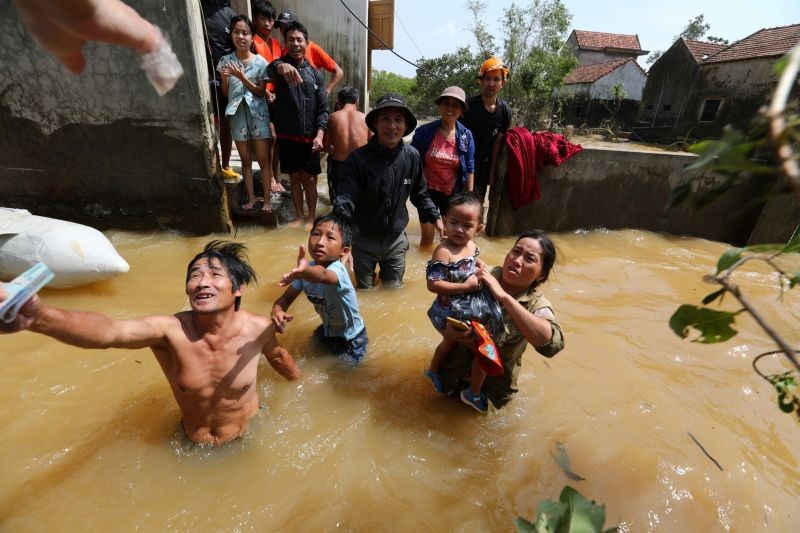 Residents get money from a volunteer at a flooded area in Quang Binh province, Vietnam October 23, 2020. (REUTERS File Photo)