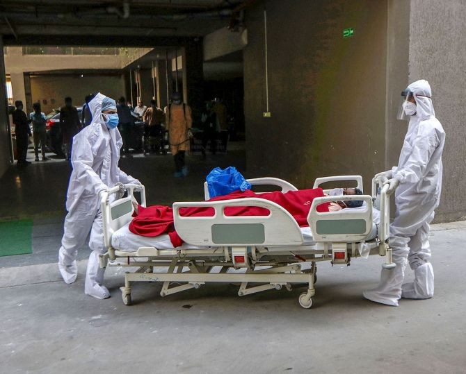 Healthcare workers wearing personnal protective equipment shift a coronavirus patient to another part of the CIMS hospital in Ahmedabad. Photograph: PTI Photo