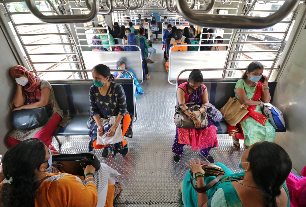 Women wearing protective face masks commute in a suburban train after authorities resumed the train services for women passengers during non-peak hours, amidst the coronavirus disease (COVID-19) outbreak, in Mumbai, October 21, 2020. REUTERS/Niharika Kulkarni