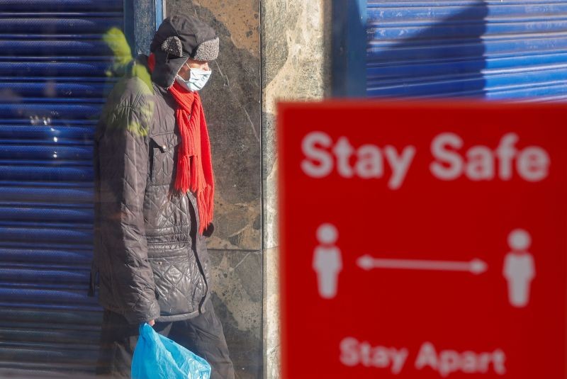 A person wearing a protective mask walks near a social distancing sign, amid the outbreak of the coronavirus disease (COVID-19), in Coventry, Britain October 25, 2020. (REUTERS Photo)