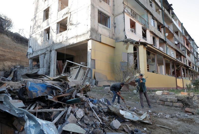 Workers remove debris near a residential building, which was damaged during the military conflict over the breakaway region of Nagorno-Karabakh, in Stepanakert October 19, 2020. (REUTERS photo)