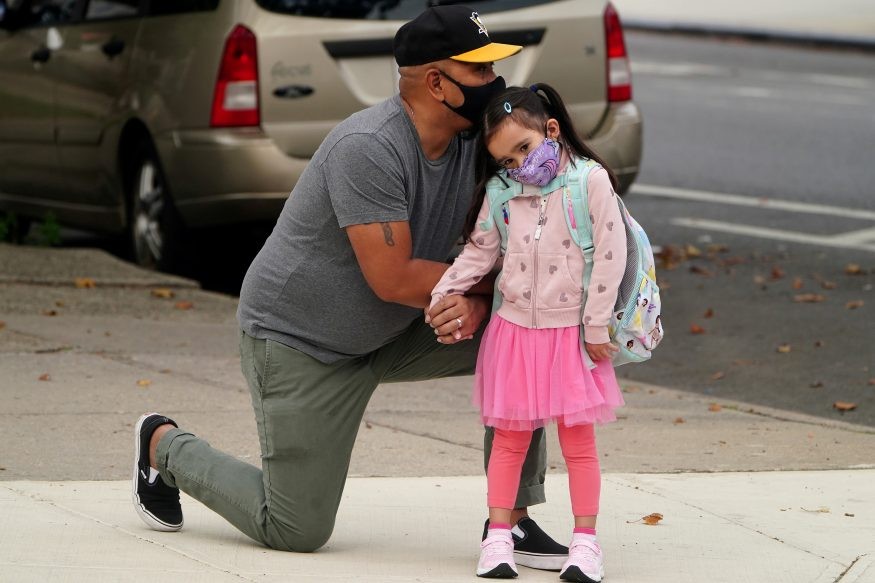 Joel Balcita comforts his daughter Sadie just before she attends her first day of grade 1 at P.S. 130 in the Brooklyn borough of New York City, New York, US. (Image: Reuters)