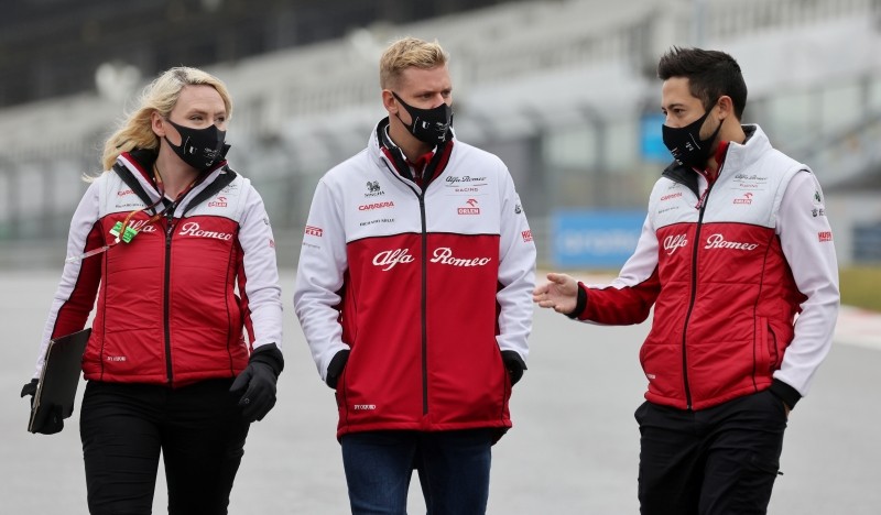 Formula One F1 - Eifel Grand Prix - Nurburgring, Nurburg, Germany - October 8, 2020 Alfa Romeo's Mick Schumacher on the circuit wearing a protective face mask with his team ahead of the Grand Prix REUTERS/Wolfgang Rattay