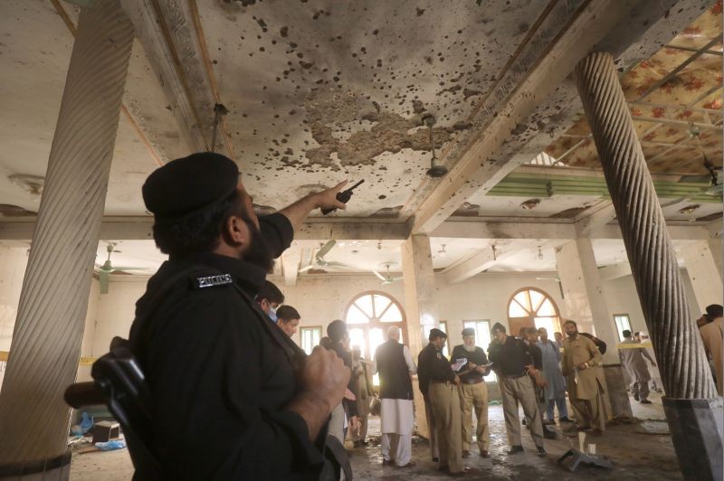 A police officer points to the damaged roof while others survey the site of a bomb blast at a religious seminary in Peshawar, Pakistan October 27, 2020. (REUTERS Photo)