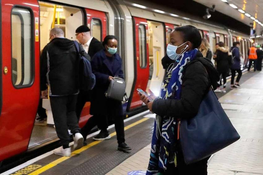 People wearing face masks to protect against the coronavirus, travel by the subway in London.  (AP Photo)