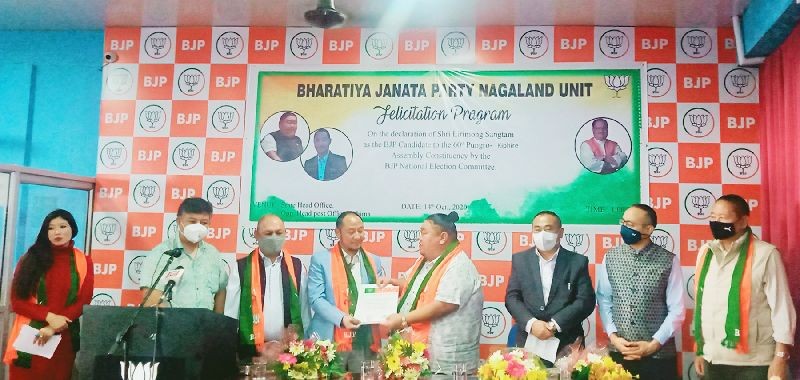 Nagaland state BJP president Temjen Imna Along hands over BJP party ticket to Lirimong Sangtam in Kohima on October 14. (Morung Photo)