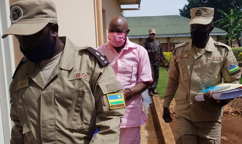 Paul Rusesabagina, portrayed as a hero in a Hollywood movie about Rwanda's 1994 genocide, is escorted in handcuffs from the courtroom in Kigali, Rwanda on October 2, 2020. (REUTERS Photo)
