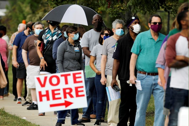 Voters wait in line to enter a polling place and cast their ballots on the first day of the state's in-person early voting for the general elections in Durham, North Carolina, U.S. October 15, 2020. (REUTERS File Photo)