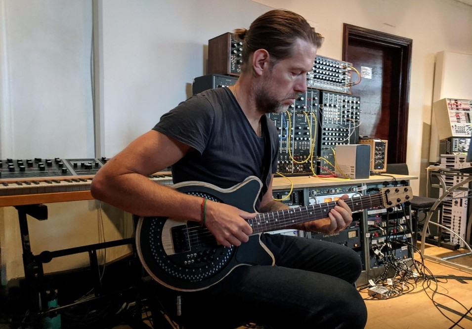 FILE PHOTO: Radiohead guitarist Ed O'Brien plays a Circle Guitar, a radical redesign of the instrument that strums itself, in a studio in London, Britain, October 1, 2020. REUTERS/Stuart McDill