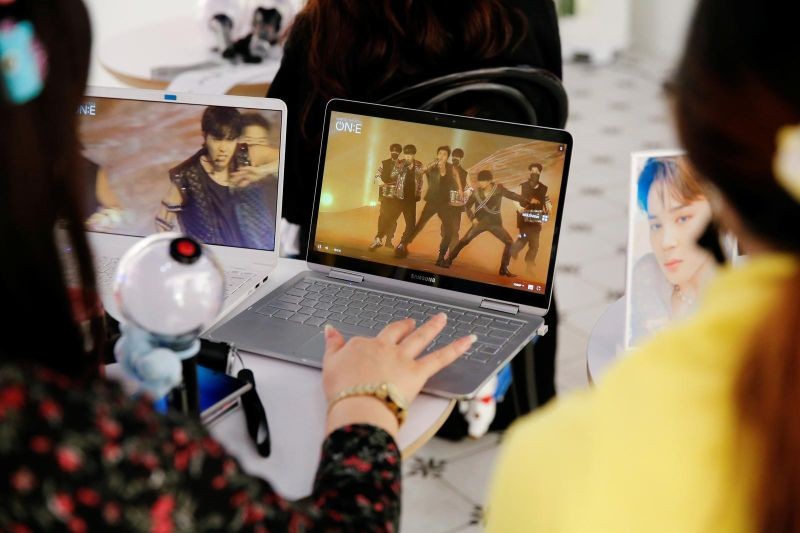 Fans of K-pop idol boy band BTS watch a live streaming online concert, wearing a protective masks to avoid the spread of COVID-19, at a cafe in Seoul, South Korea. (Reuters Photo)