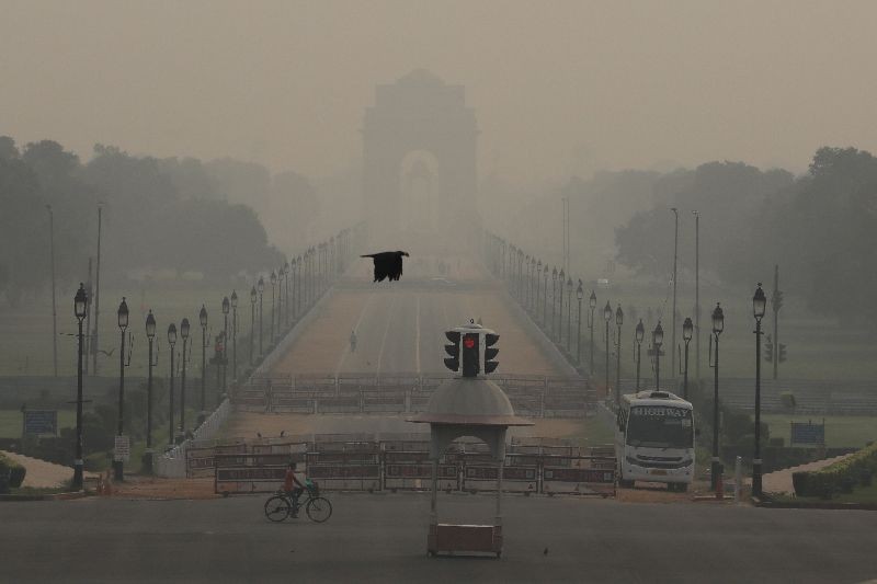 A man rides a bicycle on a hazy morning near India Gate, in New Delhi, October 14, 2020. REUTERS/Anushree Fadnavis