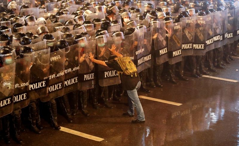 Anurak Jeantawanich, 52, pushes against police officers during an anti-government protest in Bangkok, Thailand, October 16, 2020. "I could sense danger coming," said Jeantawanich. "I looked each of them in the eye and told them not to come any closer, that there were a lot of young students and girls here." (REUTERS File Photo)