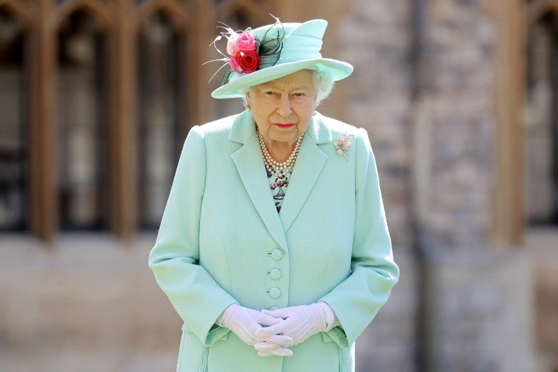 FILE PHOTO: Britain's Queen Elizabeth poses after awarding Captain Tom Moore with the insignia of Knight Bachelor at Windsor Castle, in Windsor, Britain July 17, 2020. Chris Jackson/Pool via REUTERS