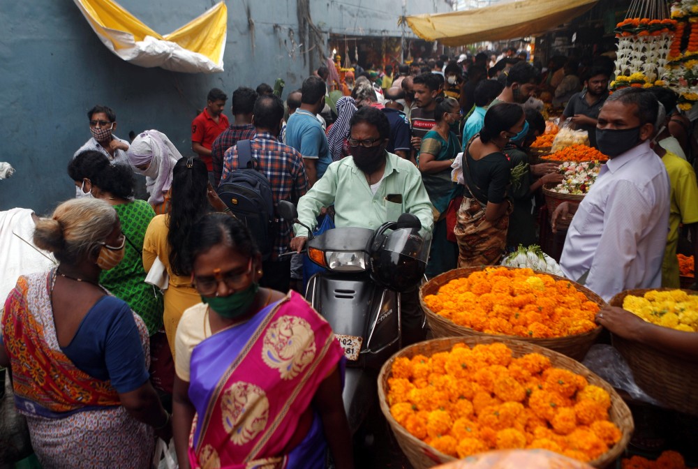 A man rides a scooter at a crowded market a day before the Hindu festival of Dussehra amidst the spread of the coronavirus disease (COVID-19) in Mumbai, India, October 24, 2020. REUTERS/Francis Mascarenhas