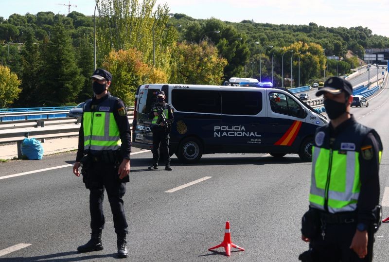 Spanish National Police officers wearing protective masks stand at a traffic checkpoint during a partial lockdown amid the outbreak of the coronavirus disease (COVID-19), in Madrid, Spain on October 5, 2020. (REUTERS File Photo)