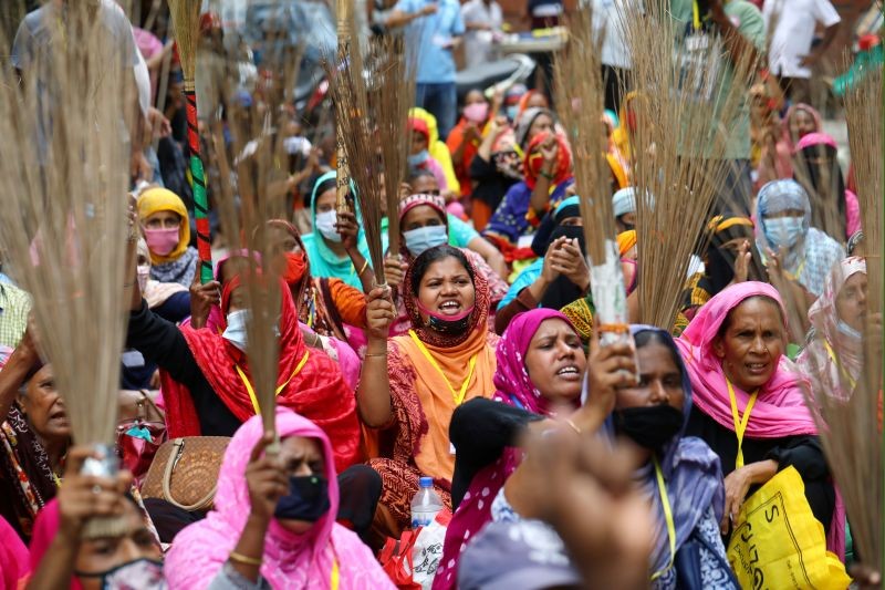 Garment workers shout slogans while holding brooms during a protest demanding their due wages in Dhaka, Bangladesh on September 7, 2020. (REUTERS File Photo)
