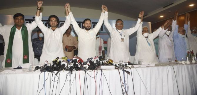 RJD leaders Tejaswi Yadav and Tej Pratap raise hands with Bihar Congress incharge Avinash Pandey, VIP party chief Mukesh Sahni and Left party leaders during the Grand Alliance's press conference ahead of Bihar Assembly elections, in Patna. Photograph: PTI Photo