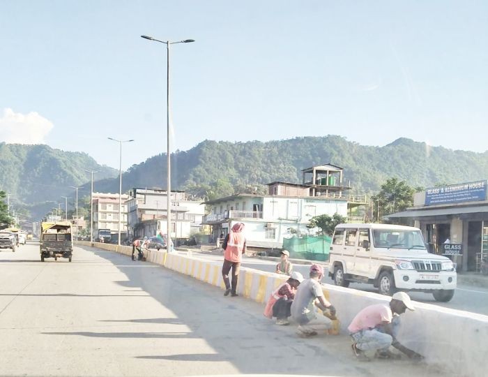 With the paving of roads almost over, workers are seen painting the lane divider of the highly anticipated project to expand and improve the Dimapur-Chümoukedima stretch of National Highway 29 on October 17. While the ceremonial foundation stone, signaling the commissioning of the work, was laid down in January 2018 and it was expected to be completed by September 2019, several factors have delayed the project, including the ongoing COVID-19 pandemic.   As per the project specifications, the total length of the road from the New Field Checkpost to Chümoukedima runs 17.3km, while the 4-lane segment from Purana Bazaar to Chümoukedima runs a length of 12.9km. As of October 18, pavement of road is almost done, barring final touches in various intersections. Workers were also seen constructing a foot over-bridge at the 4th Mile NER Agri-Expo Junction as well as repairing/constructing unfinished drainage and damaged dividers. (Morung Photo)