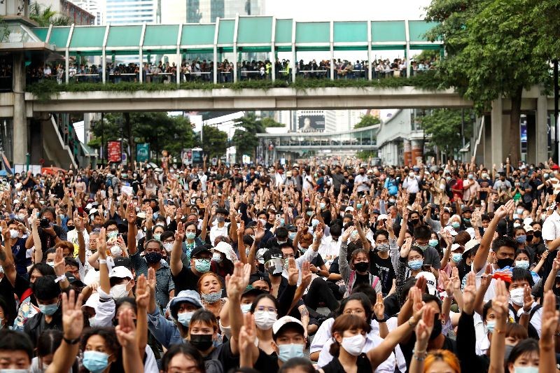 Pro-democracy protesters show the three-finger salute as they gather demanding the government to resign and to release detained leaders in Bangkok, Thailand October 15, 2020. REUTERS/Jorge Silva