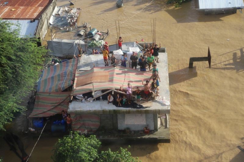 People stand on a roof of a building after Typhoon Vamco resulted in severe flooding, in the Cagayan Valley region in the Philippines, November 14, 2020. (REUTERS Photo)