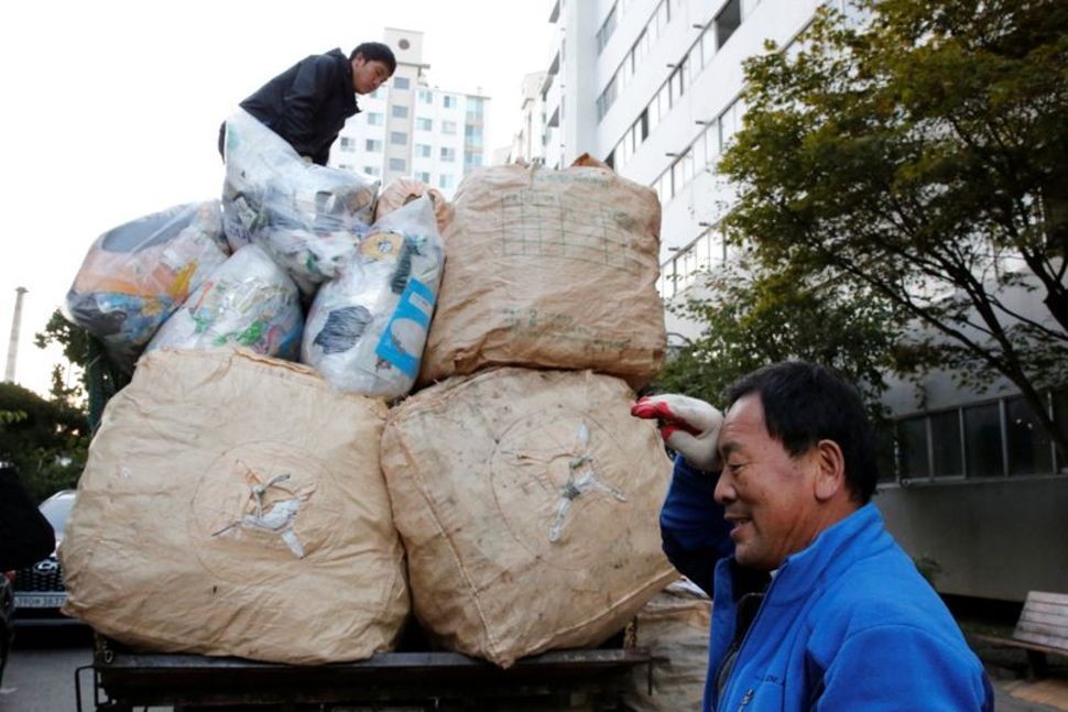 Lee Yong-gi, owner of a recycling facility, wipes sweat from his brow after collecting sacks of recycling garbage at an apartment area in Seoul, South Korea, October 23, 2020. Picture taken October 23, 2020. (Reuters Photo)