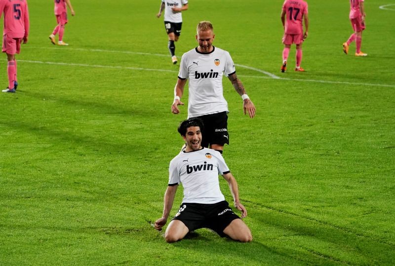 Valencia's Carlos Soler celebrates scoring their fourth goal and completing his hat-trick with Uros Racic REUTERS/Juan Medina