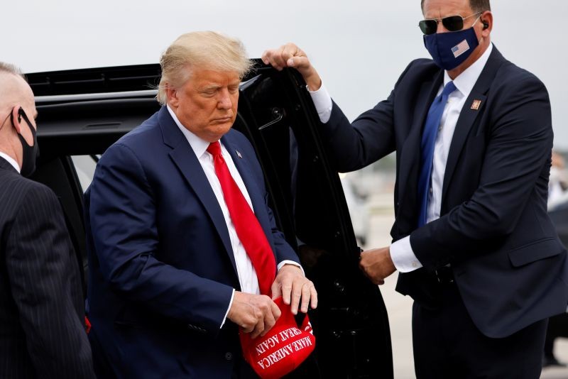 U.S. President Donald Trump holds a 'Make America Great Again' cap while arriving to board Air Force One as he departs Florida for campaign travel to North Carolina, Pennsylvania, Michigan and Wisconsin at Miami International Airport in Miami, Florida, U.S., November 2, 2020. (REUTERS Photo)
