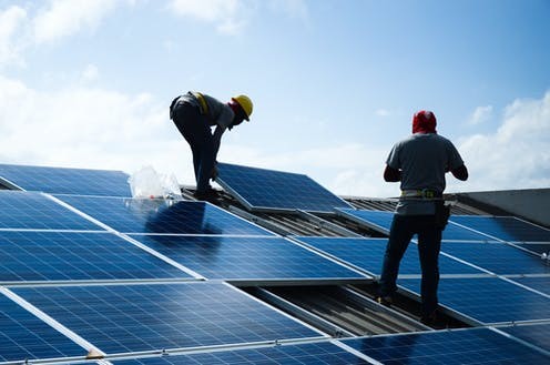 Installing solar panels on a roof. Shutterstock/lalanta71