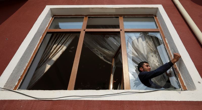 A man removes glass from a window that was allegedly damaged by recent shelling during the fighting over the breakaway region of Nagorno-Karabakh, in the city of Tartar, Azerbaijan November 2, 2020. (REUTERS Photo)