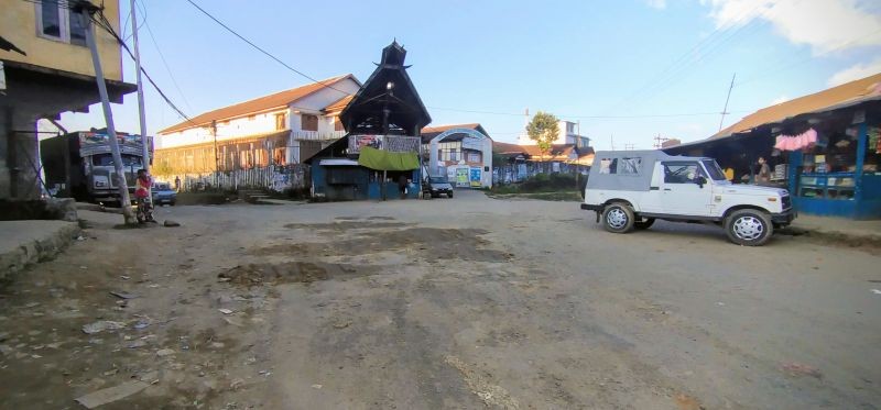 Members of The Gigglers and United Labours Society filling up a pothole with gravel and soil at High School Junction, Tuensang town on November 7. (Morung Photo)